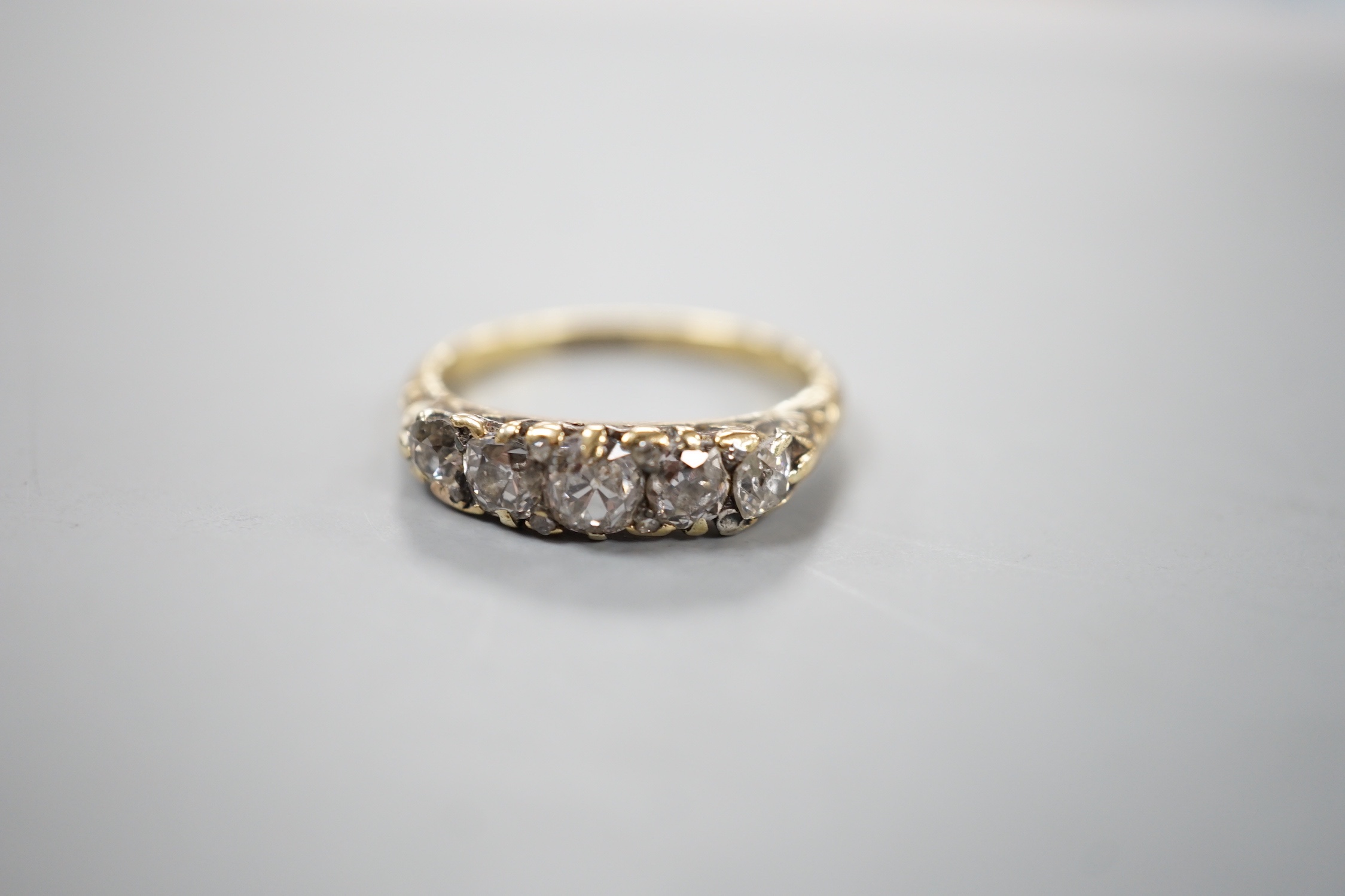 An 18ct and graduated five stone diamond set half hoop ring, size M, gross weight 3.5 grams.